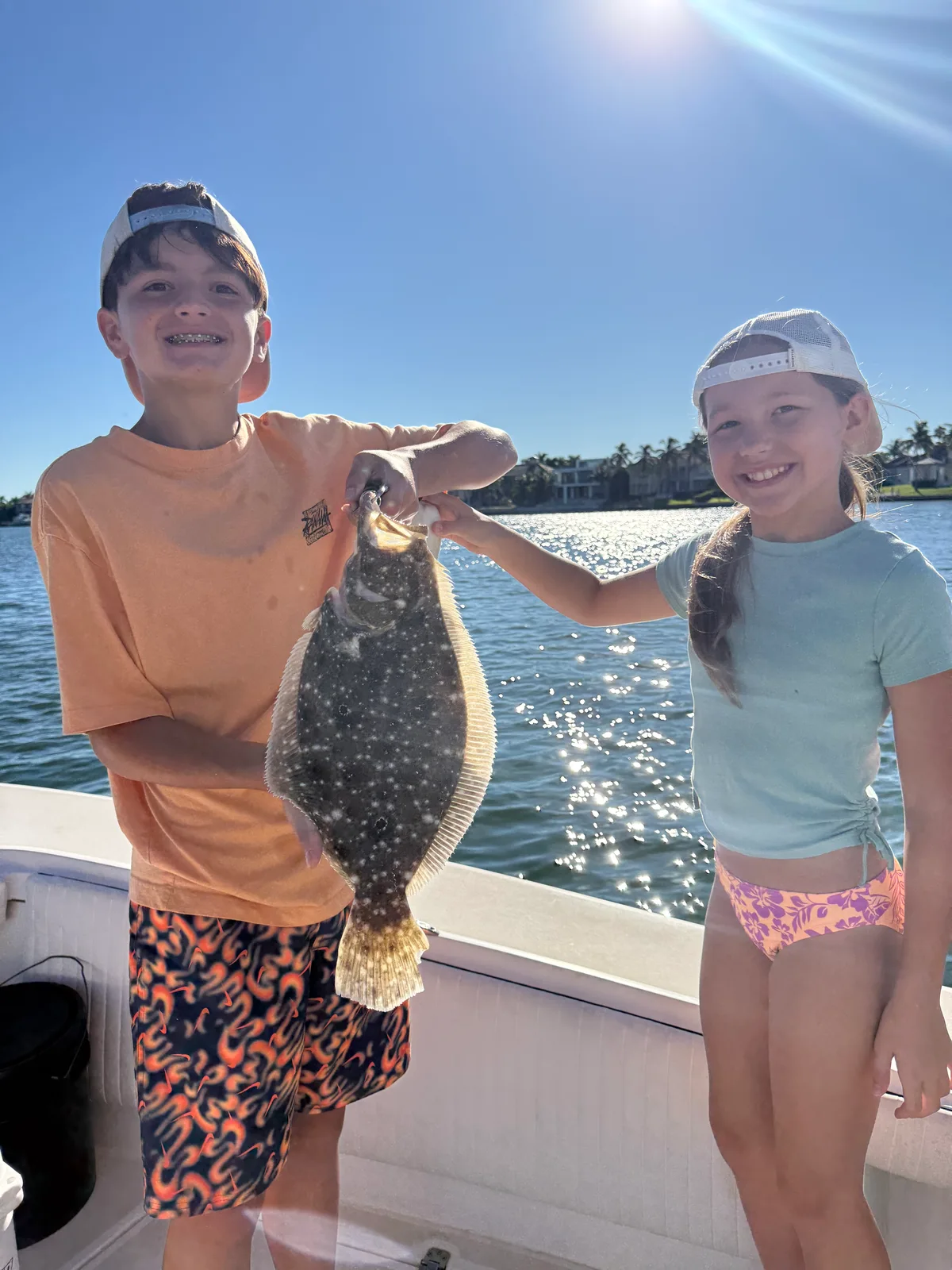 Two young anglers hold a flounder aboard a Sarasota fishing trip — October 15, 2026.