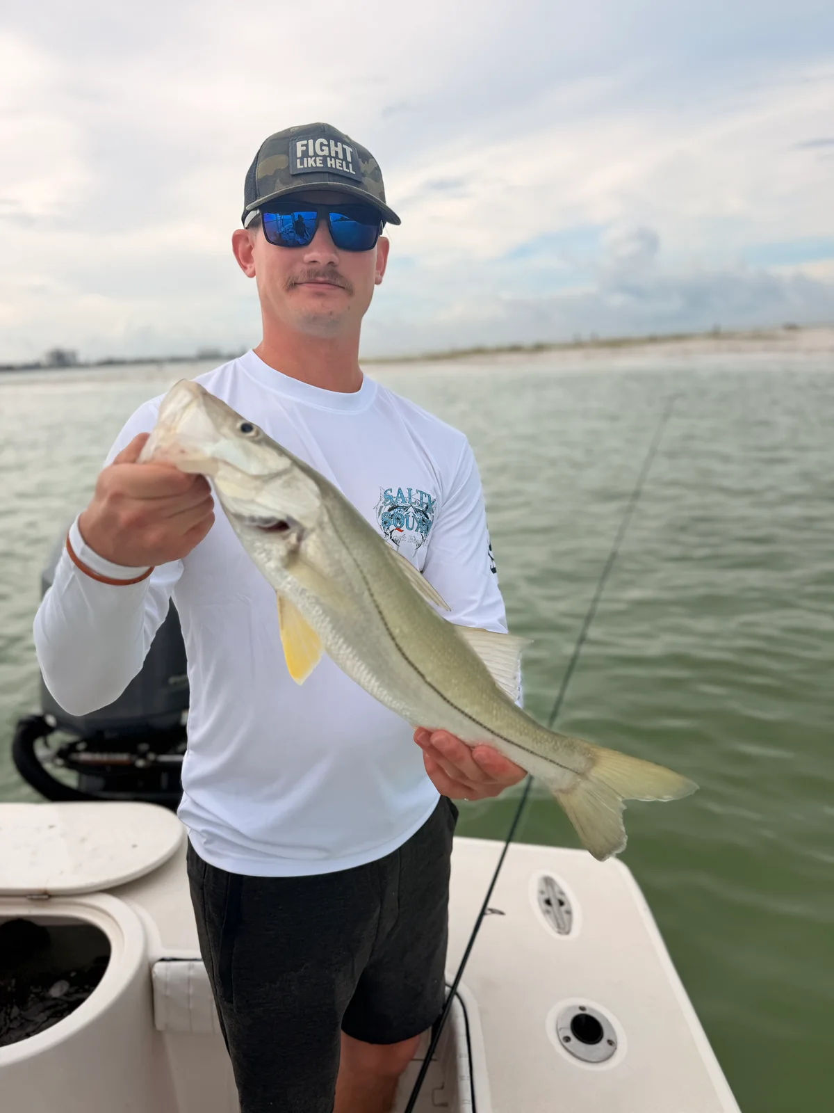 Angler holds a snook aboard a boat during a Sarasota fishing trip — October 9, 2026.